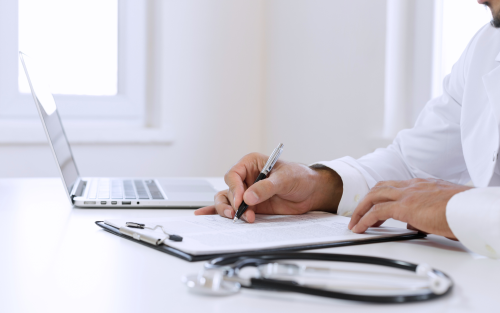 Doctor writing with computer